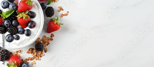 A healthy snack or breakfast option of Greek yogurt granola with fresh berries is beautifully presented on a stone table seen from a top view with ample space for additional images or text