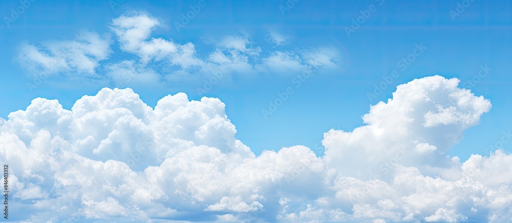 A serene backdrop of a clear blue sky adorned with fluffy white clouds sets the stage for a copy space image A serene backdrop of a clear blue sky adorned with fluffy white clouds sets the stage for a copy space image