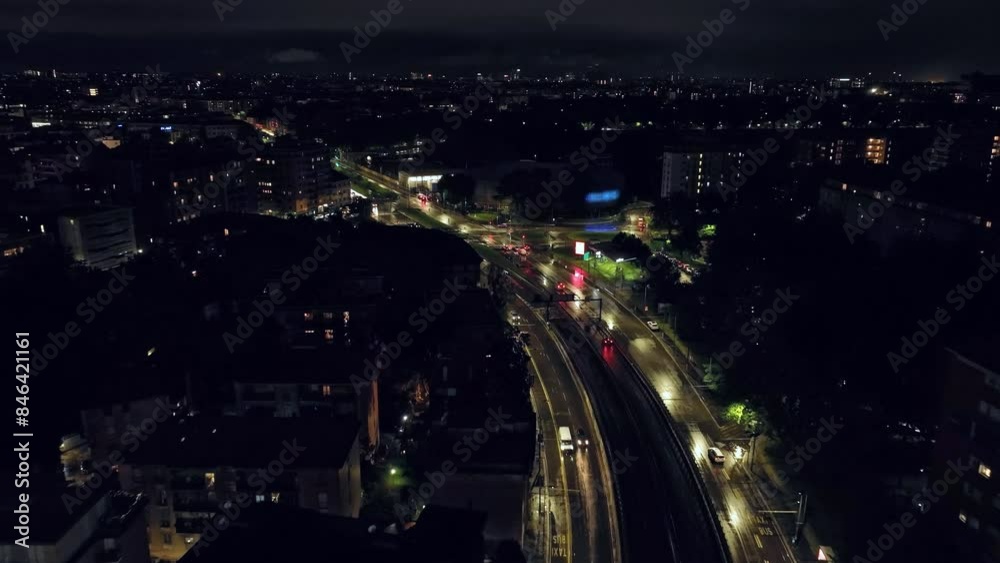Milan's Nighttime Charm: Aerial View of the Cityscape Illuminated by City Lights, High-Rise Towers, and the Twinkling of Car Headlights in the Streets Below. High quality 4k footage