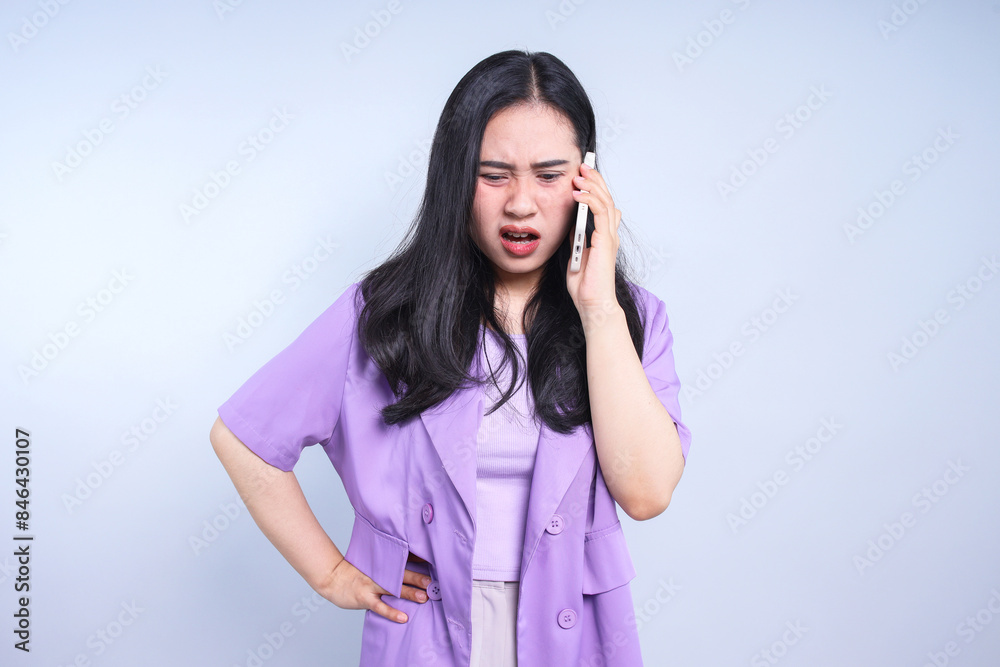 Worried Asian woman talking on the phone feeling frustrated isolated on white background Worried Asian woman talking on the phone feeling frustrated isolated on white background