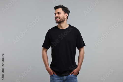 Smiling man in black t-shirt on grey background