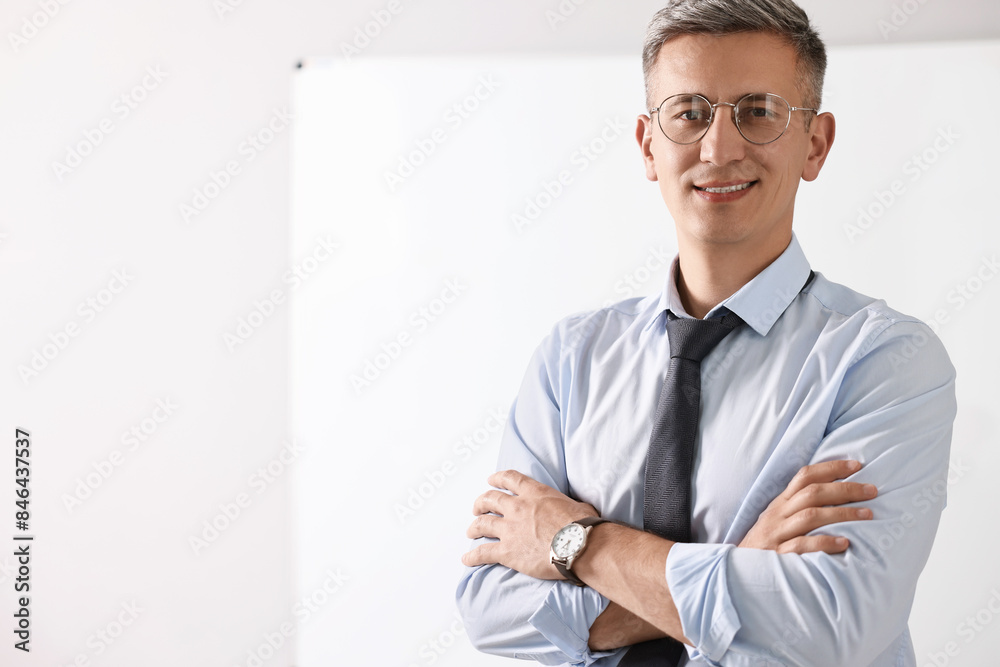Teacher near whiteboard in classroom, space for text