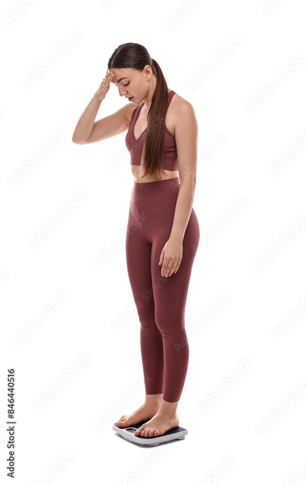 Worried woman standing on floor scale against white background Worried woman standing on floor scale against white background