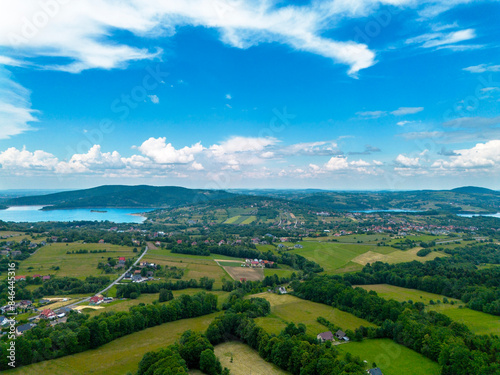 Aerial view of villages, lake and beautiful green hills under a blue sky