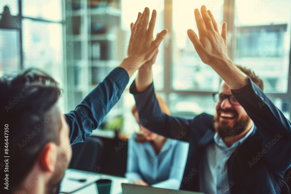 Fototapeta premium Close-up of business colleagues high fiving professionally in a modern office setting