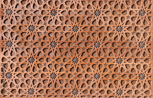 Detail of wooden door with traditional islamic ornament. Wood window shutter with antique iranian geometric pattern. Oriental ornament with artistic carving for wood