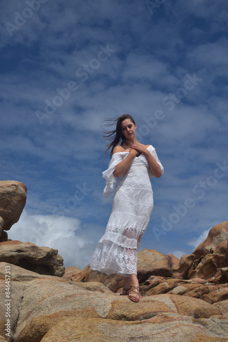 Wallpaper Mural portrait of female model  standing wearing white goddess dress, dramatic natural landscape background of rocky ocean shoreline with stone clifftops. castle rock, Busselton, Western Australia Torontodigital.ca