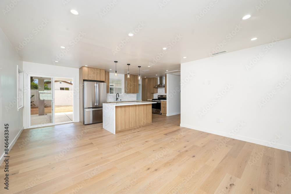 Obraz premium empty kitchen and dining area with wood flooring and white walls