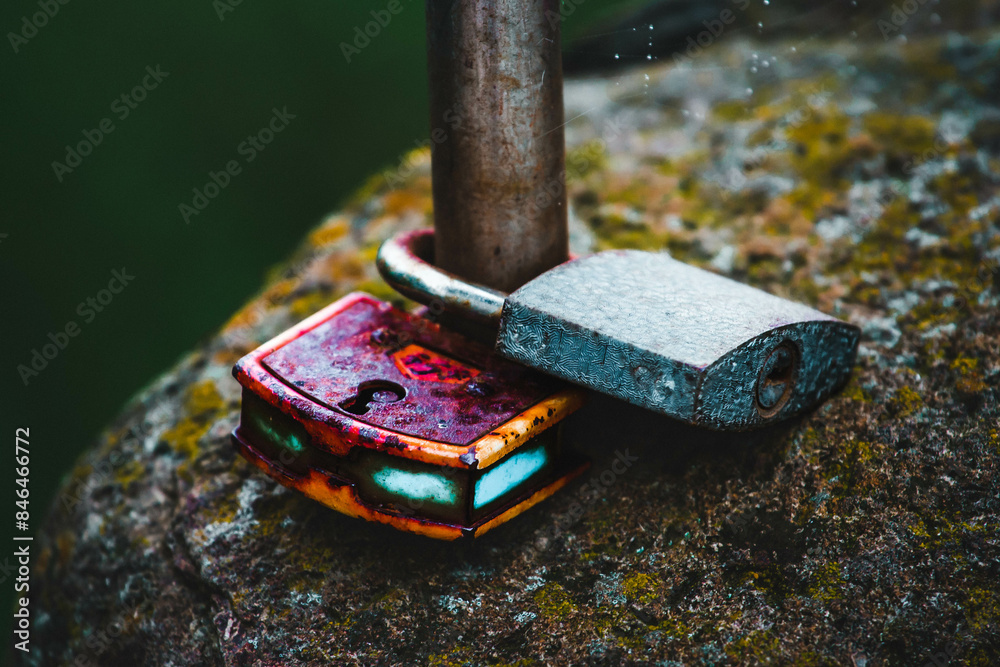 Wet old rusty locks firmly mounted on a wet stone in the rain. Wet old rusty locks firmly mounted on a wet stone in the rain.