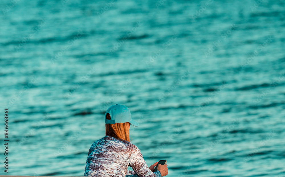 Woman wearing a blue hat by the sea Woman wearing a blue hat by the sea