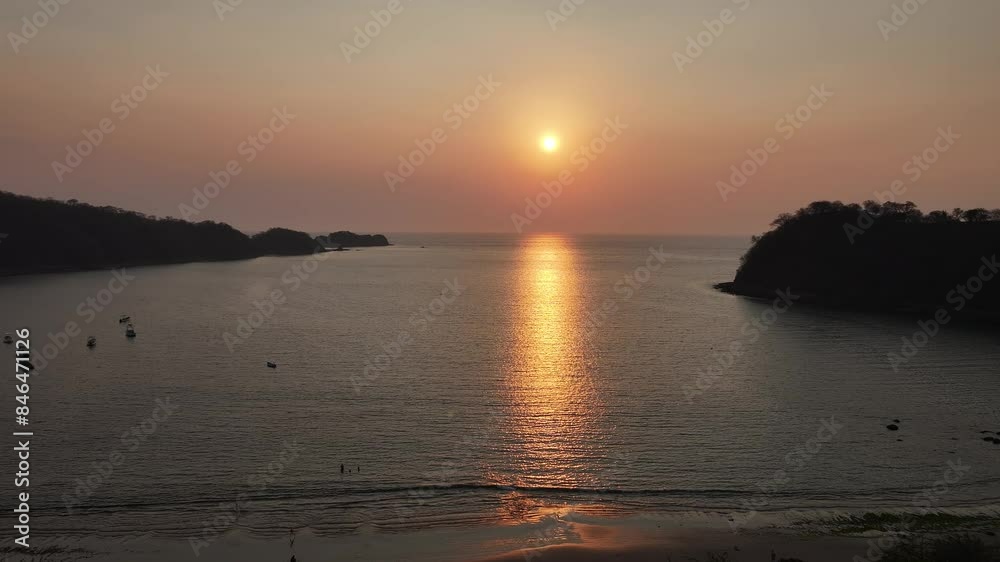 epic sunset with pink sky over the Pacific Ocean with some moored boats in El Jobo, Costa Rica epic sunset with pink sky over the Pacific Ocean with some moored boats in El Jobo, Costa Rica