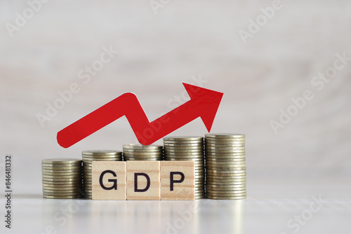 Red arrow on coins money and gdp word on wooden background, GDP (Gross Domestic Product) concept