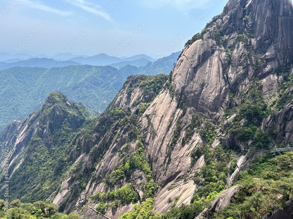 a woman stands on the top of a mountain overlooking green hills a woman stands on the top of a mountain overlooking green hills