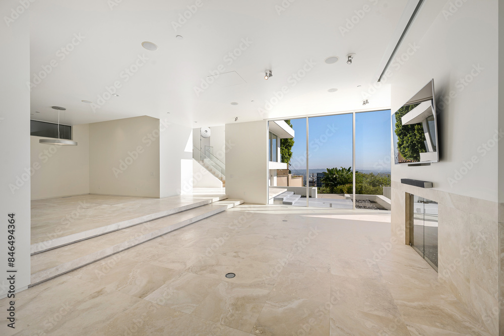 Fototapeta premium Spacious living room with a large flat-screen TV mounted on a white wall. California, USA