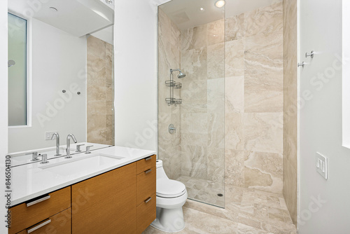Modern bathroom with walk-in shower, toilet, vanity, and glass shower enclosure