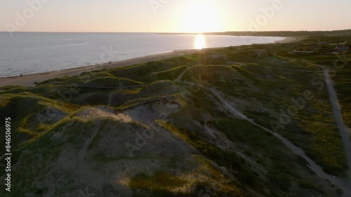 Sand hills and beach with green grass in sunset photo