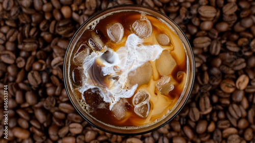 Pouring milk in coffee with ice, top view