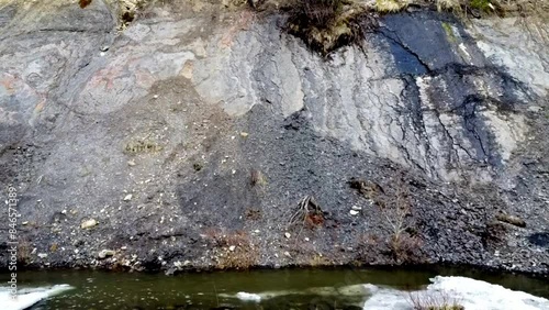 Small river flowing with gravel and other things.