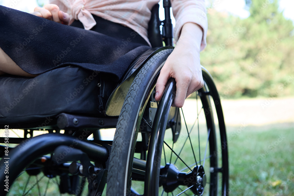 Person using a wheelchair in a park setting, demonstrating mobility and independence Person using a wheelchair in a park setting, demonstrating mobility and independence