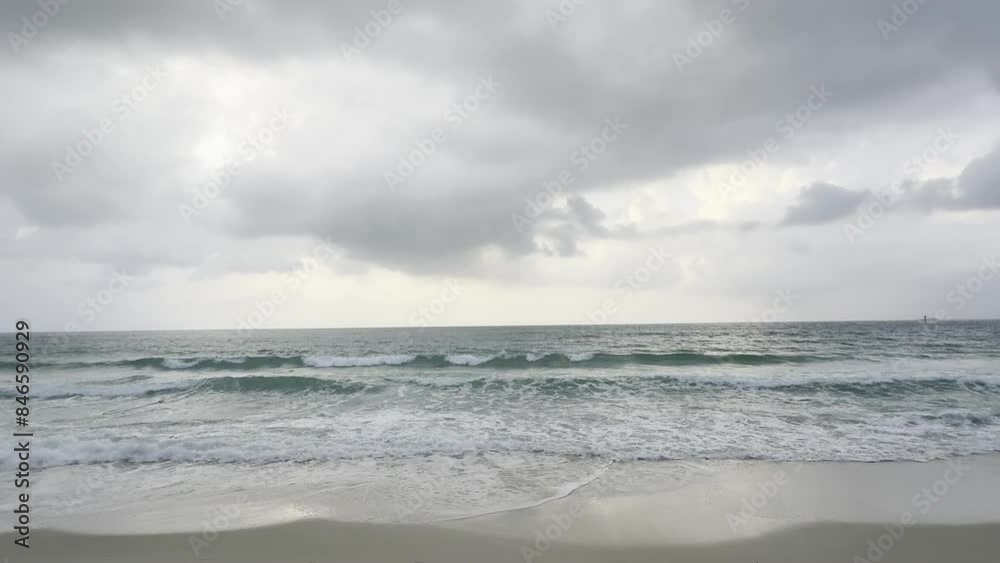 Landscapes.Grey sky and the rain is falling. The sea has small waves crashing against the sandy beach. Landscapes.Grey sky and the rain is falling. The sea has small waves crashing against the sandy beach.