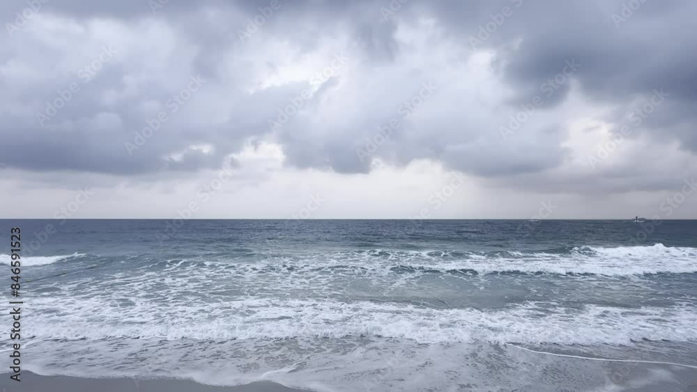 Ocean waves crashed on the sandy beach, creating white foam and gray morning clouds. Ocean waves crashed on the sandy beach, creating white foam and gray morning clouds.