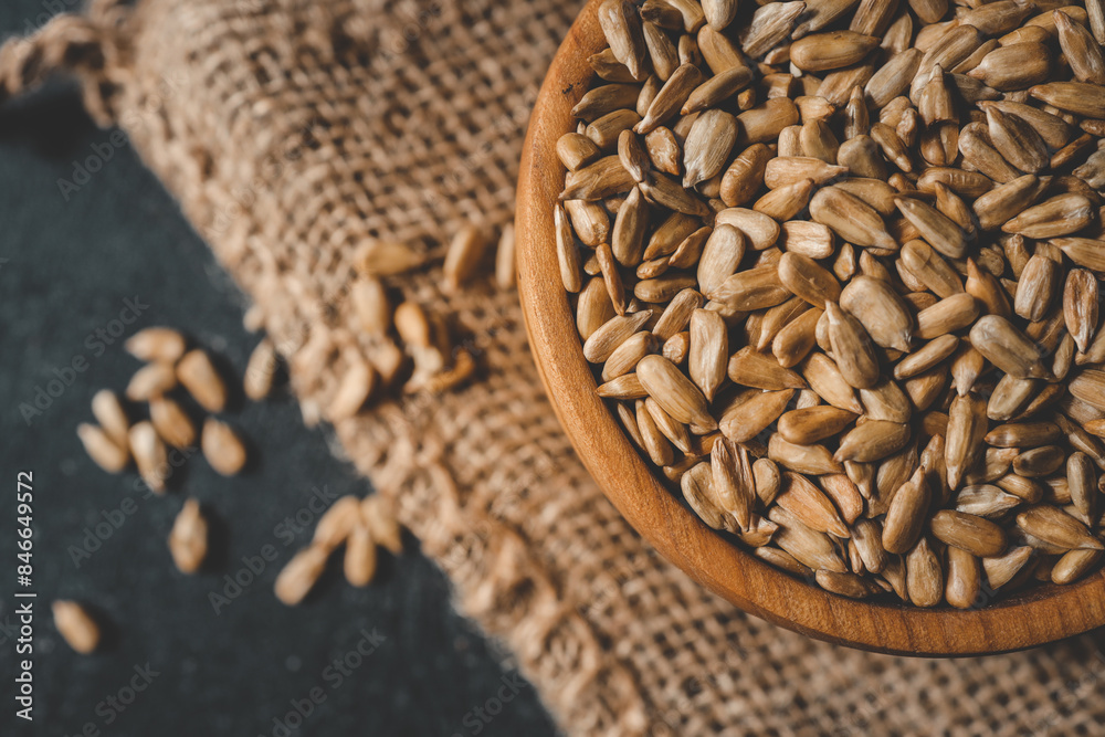 Sunflower seeds in wooden bowl on a rural background Sunflower seeds in wooden bowl on a rural background