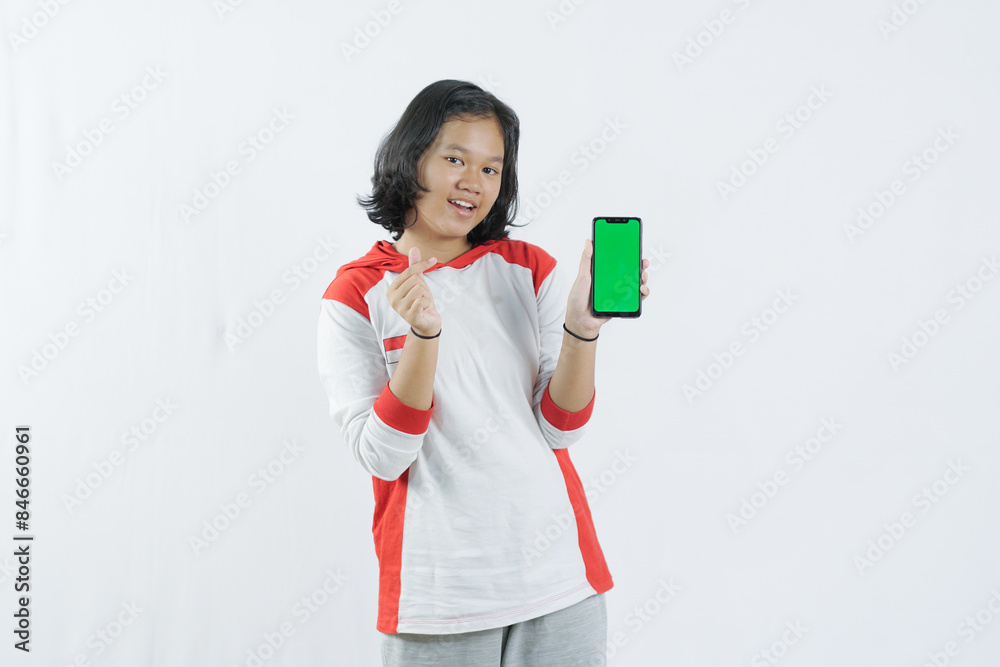 Young Asian woman looks happy in Indonesian Independence Day attire. woman shows her mobile phone with green screen suitable for advertising Young Asian woman looks happy in Indonesian Independence Day attire. woman shows her mobile phone with green screen suitable for advertising