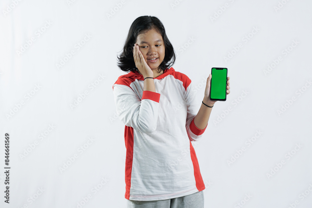 Young Asian woman looks happy in Indonesian Independence Day attire. woman shows her mobile phone with green screen suitable for advertising Young Asian woman looks happy in Indonesian Independence Day attire. woman shows her mobile phone with green screen suitable for advertising