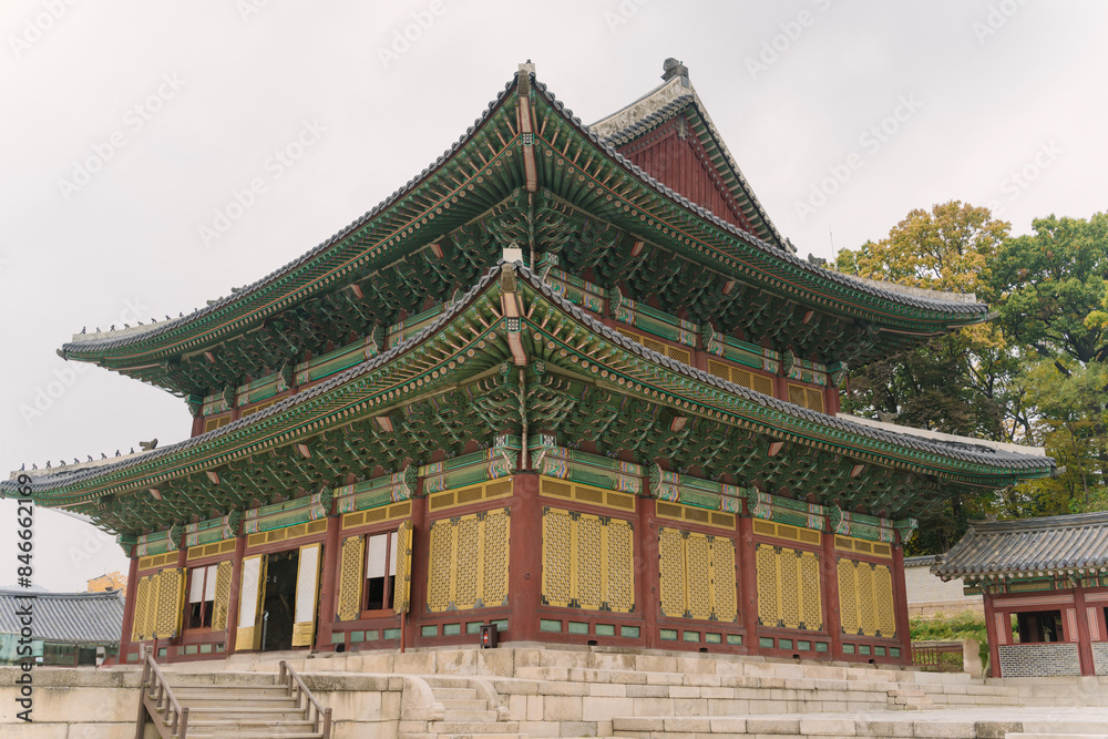 Gyeongbokgung Palace in Seoul, Korea, with visitors in traditional and modern attire walking on the spacious stone courtyard under an overcast sky. Gyeongbokgung Palace in Seoul, Korea, with visitors in traditional and modern attire walking on the spacious stone courtyard under an overcast sky.