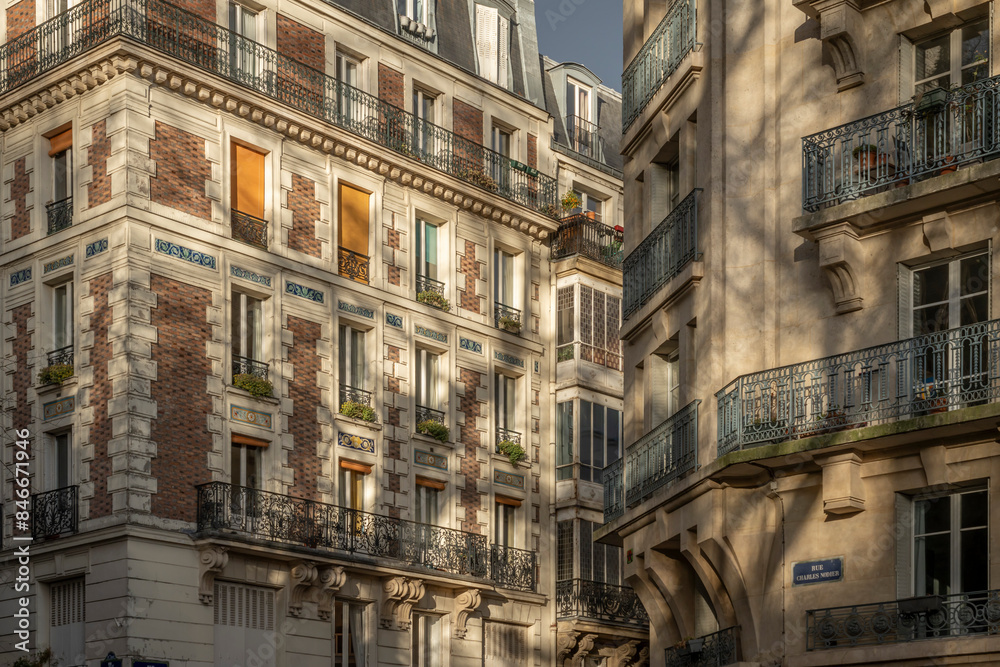 Fototapeta premium Paris, France - 02 25 2023: . View of Montmartre district and buildings from a street at golden hour.