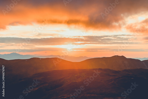Wallpaper Mural Bright orange sunset sun over mountain range. Stunning wild nature sunrise. Panoramic view of beautiful mountain landscape. Travel, tourism, adventure, concept image. Carpathian mountains, Ukraine Torontodigital.ca