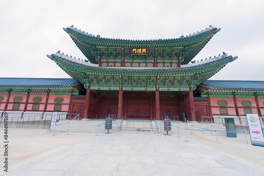 entrance of Gyeongbokgung Palace in Seoul, adorned with intricate designs and vibrant colors, standing majestically under a cloudy sky, reflecting Korea’s rich historical entrance of Gyeongbokgung Palace in Seoul, adorned with intricate designs and vibrant colors, standing majestically under a cloudy sky, reflecting Korea’s rich historical