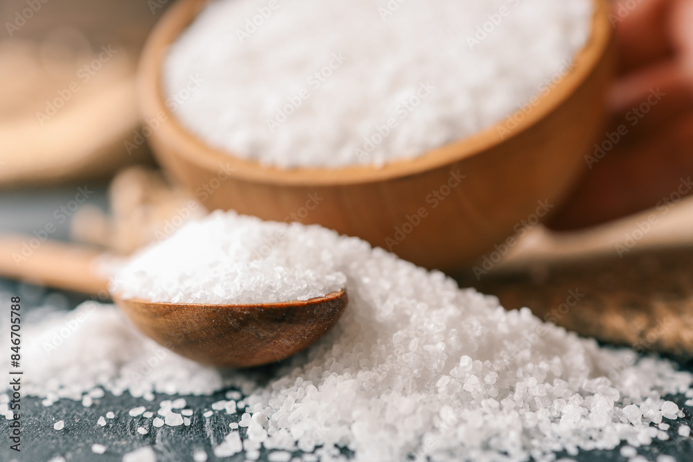 Pour salt into a wooden spoon, close-up Pour salt into a wooden spoon, close-up