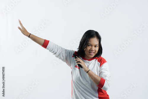 a young Indonesian woman raises her pointing finger with a big smile, the concept of Indonesia's independence day on August 17, isolated on a white background.