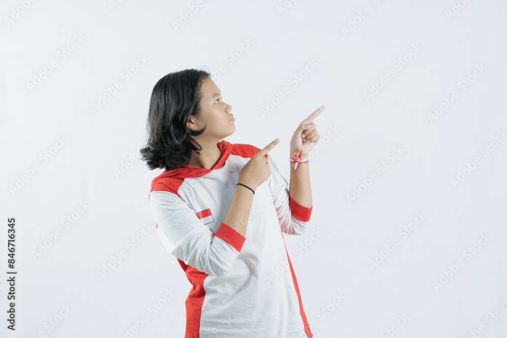 a young Indonesian woman raises her pointing finger with a big smile, the concept of Indonesia's independence day on August 17, isolated on a white background. a young Indonesian woman raises her pointing finger with a big smile, the concept of Indonesia's independence day on August 17, isolated on a white background.