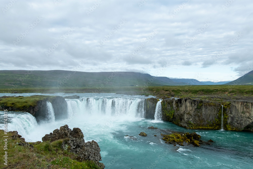 Icelandic landscape of the body of water, lakes and waterfall on a cloudy day from Akureyri