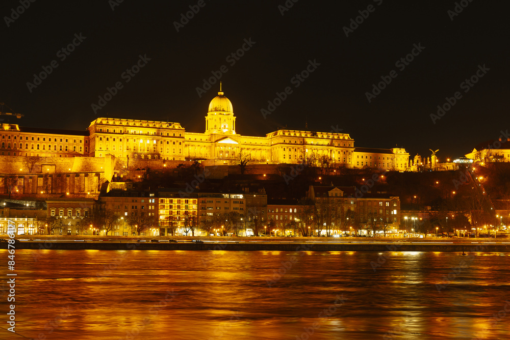 A magnificent historic building glows in the night, mirroring on a serene river, forming a dazzling view A magnificent historic building glows in the night, mirroring on a serene river, forming a dazzling view