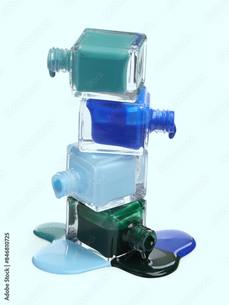 Different nail polishes dripping from open bottles on white background Different nail polishes dripping from open bottles on white background