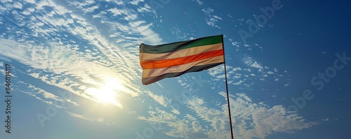 Niger flag flying against a bright, blue sky photo