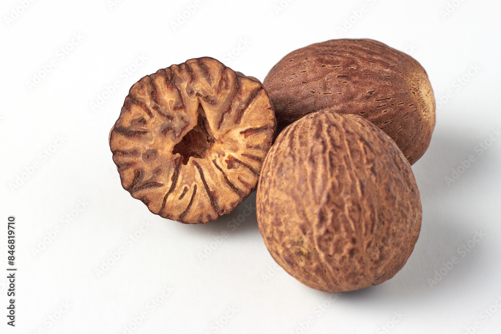 Dried nutmegs isolated on a white background. A flavorful spice for cooking Dried nutmegs isolated on a white background. A flavorful spice for cooking