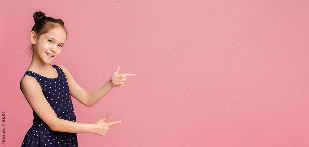 Cute little girl smiling and pointing aside, showing something at blank space, pink panorama background Cute little girl smiling and pointing aside, showing something at blank space, pink panorama background