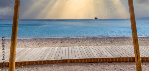 Wooden floor on sandy beach of the Red Sea in cloudy morning