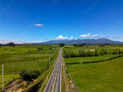 Aerial view of road leading to snow capped Mount Taranaki (volcano) and side profile of Egmont National Park