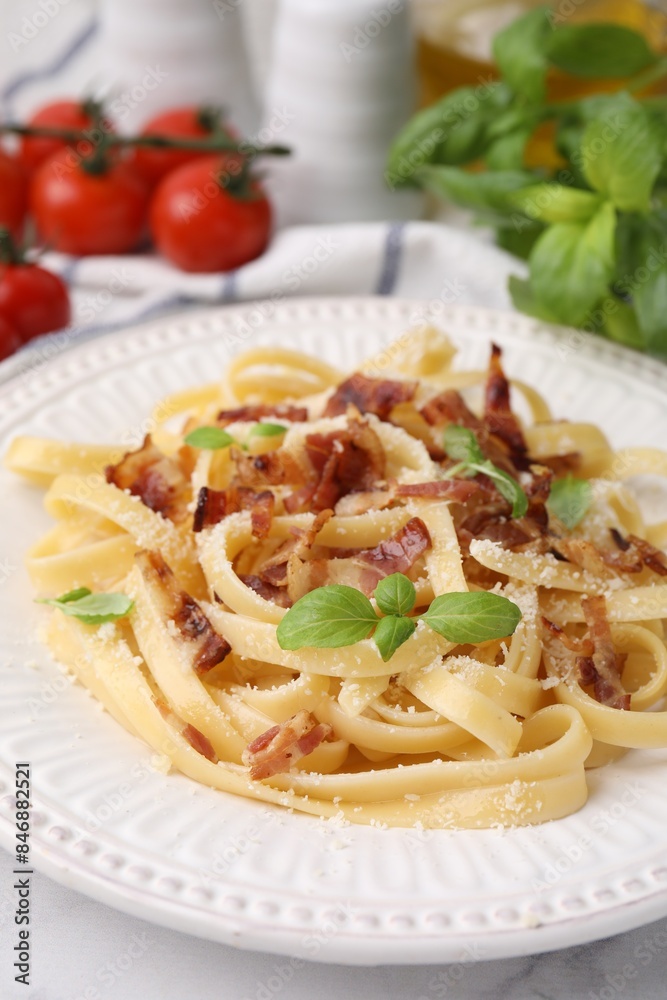 Tasty pasta with bacon and basil on white table, closeup Tasty pasta with bacon and basil on white table, closeup