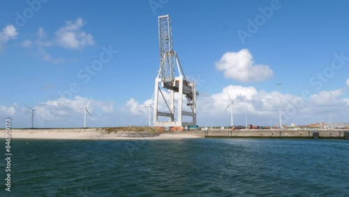 Rotterdam, The Netherlands - April 24, 2024: Large gantry cranes and container ship - port of Rotterdam - Maasvlakte. The Maasvlakte is a massive westward extension of the Europoort port photo