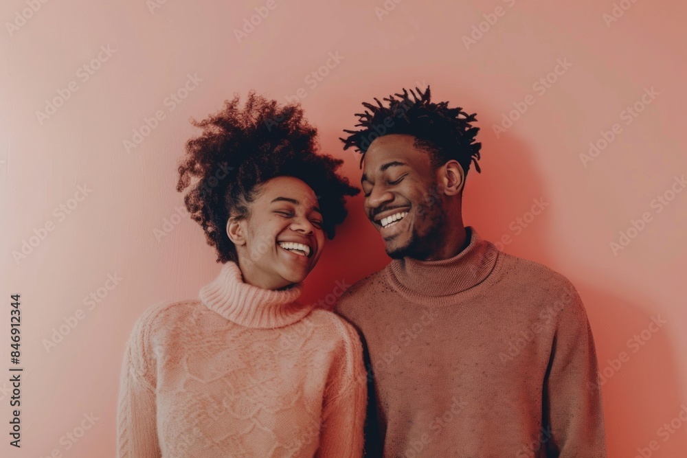 Portrait of a cheerful afro-american couple in their 30s dressed in a warm wool sweater on solid pastel color wall Portrait of a cheerful afro-american couple in their 30s dressed in a warm wool sweater on solid pastel color wall