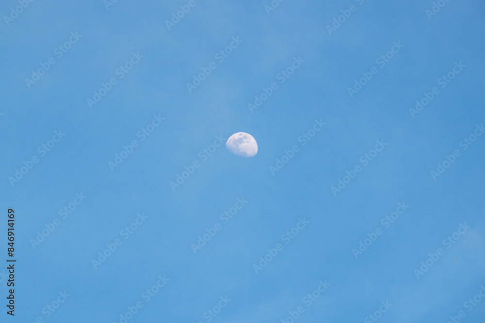 Moon in the blue sky with white clouds, good weather day Moon in the blue sky with white clouds, good weather day