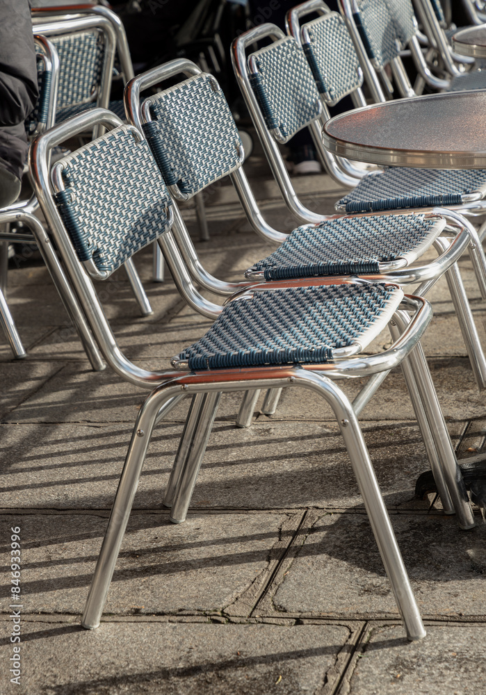 Empty outdoor cafe seating area with Stainless steel chairs on street. Metal chairs outside a cafe in Paris city, Space for text, Selective focus. Empty outdoor cafe seating area with Stainless steel chairs on street. Metal chairs outside a cafe in Paris city, Space for text, Selective focus.