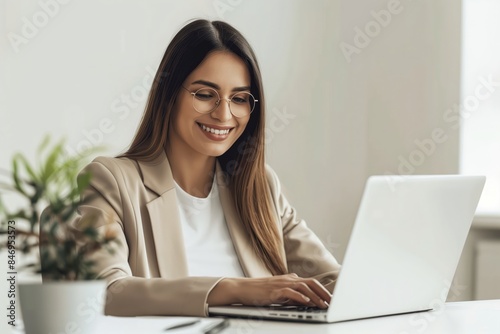 Professional Woman Smiling While Working on a Laptop