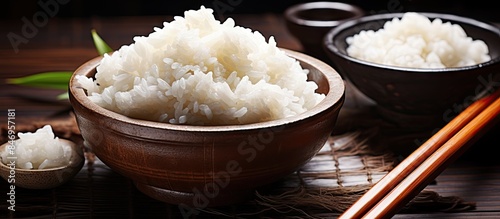 Chopsticks placed near bowls of rice beside soaked sticky rice for Chinese cuisine preparation. with copy space image. Place for adding text or design photo